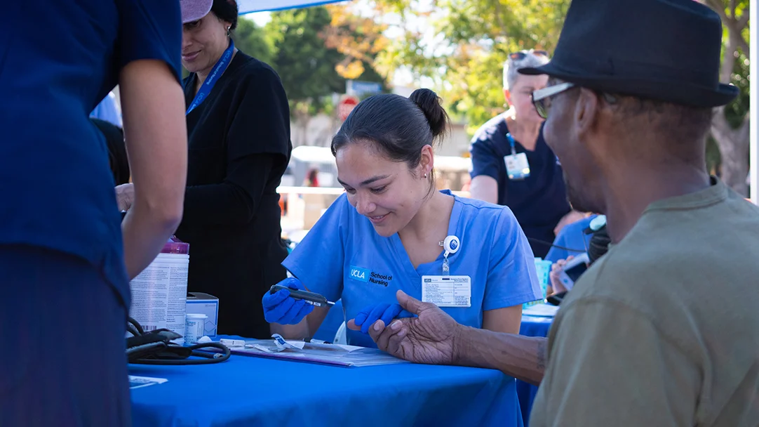 A UCLA nrusing student providing a health screening