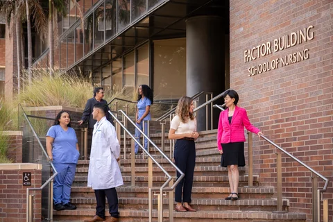 UCLA Nursing Dean Lin Zhan speaking with students in front of the School of Nursing.