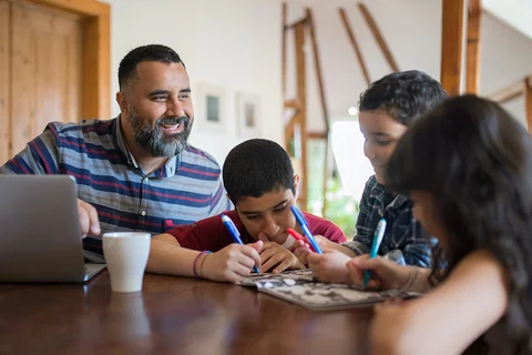 A stock photo of a dad working with his children