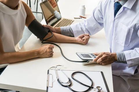 A doctor checking the blood pressure of a patient. 