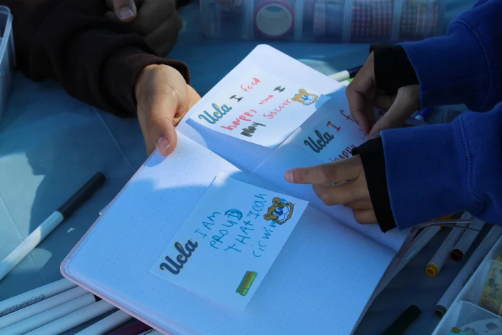 Close-up of hands pointing at notes written by elementary students at the Move & munch event.