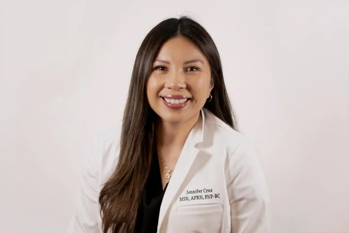 Jeffifer Cruz wearing a white lab coat.