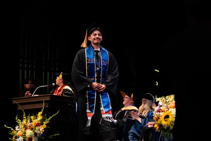 Nursing student walking across the commencement stage.