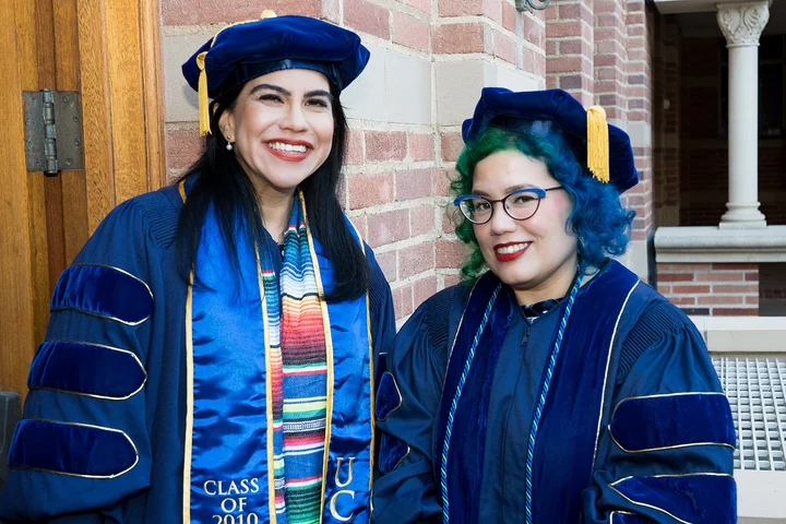 2 PhD students in their cap and gowns.