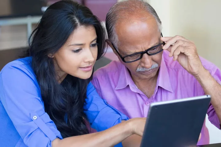 A man and woman looking at a tablet together