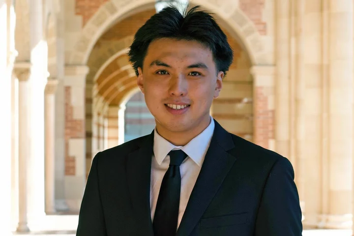 Xavier Ren wearing a black suit on the UCLA campus.