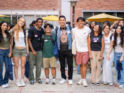 Students standing up and smiling taking a group picture