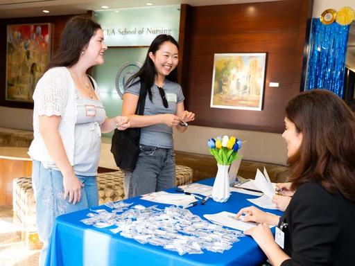 Two people at the table tending to two students standing up