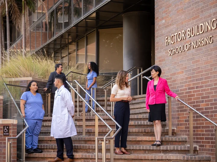 UCLA Nursing Dean Lin Zhan speaking with students in front of the School of Nursing.