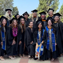 A group of UCLA Nursing master's students and faculty posing in their regalia