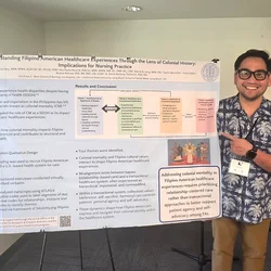 Paolo Roca standing with a research poster he presented at a recent conference.