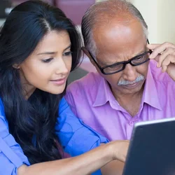 A man and woman looking at a tablet together