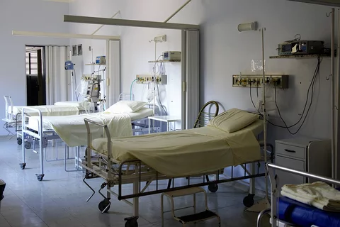 A hospital room with multiple empty beds
