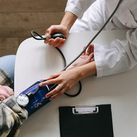 A stock image of a doctor checking blood pressure of a patient